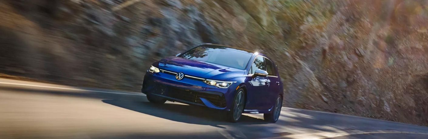 One blue color 2022 Volkswagen Golf R is running on the road.