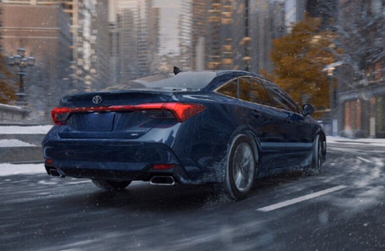 Blue 2021 Toyota Avalon driving on a snowy street
