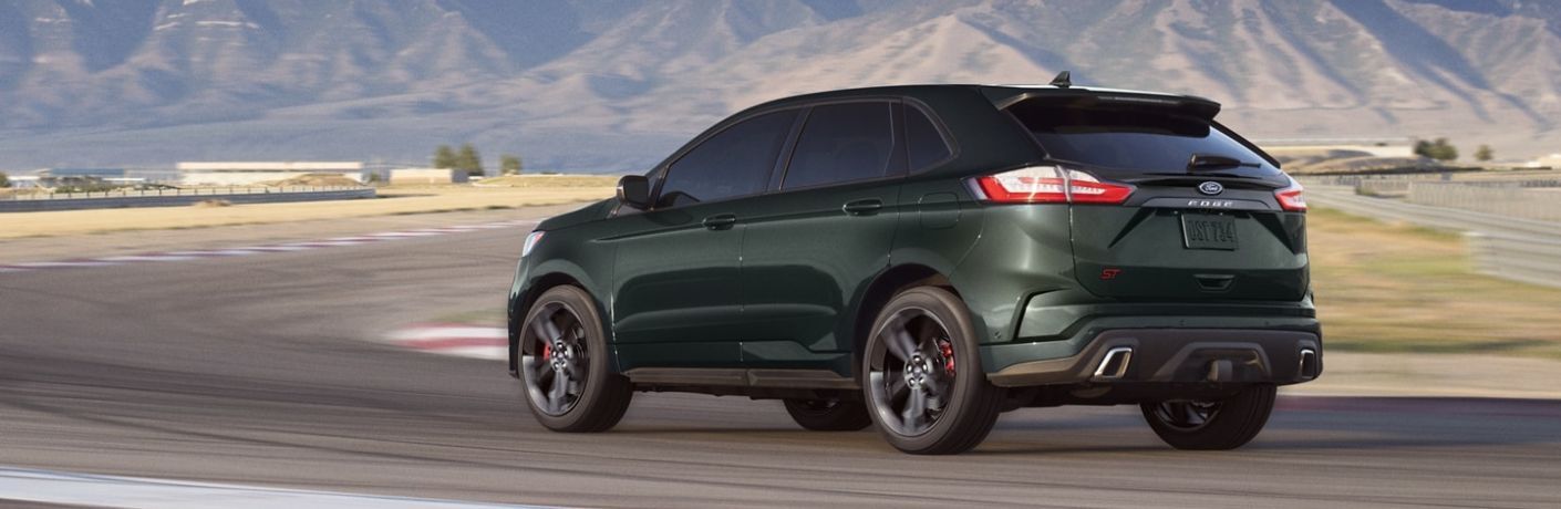 One green color 2022 Ford Edge is running on the road.