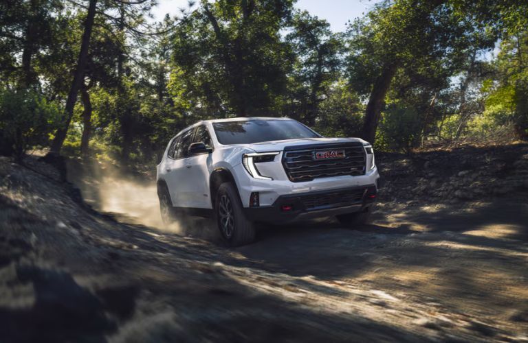 2025 GMC Acadia front view driving on a dirt trail
