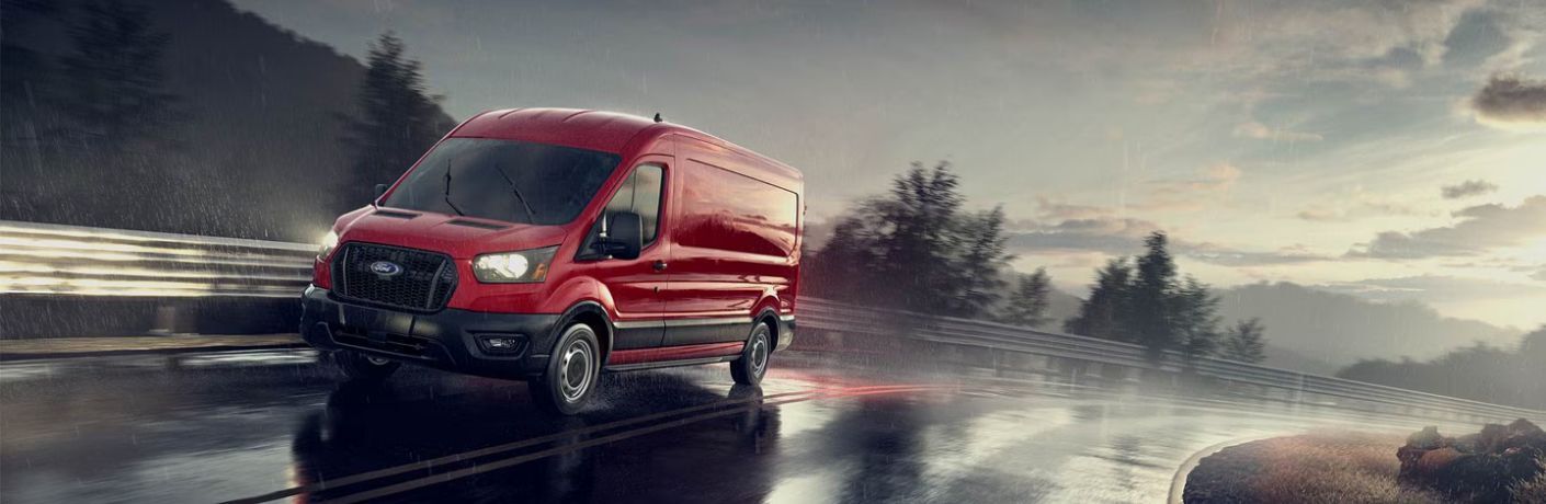 2025 Ford Transit XL Passenger Van front and side view on a wet road