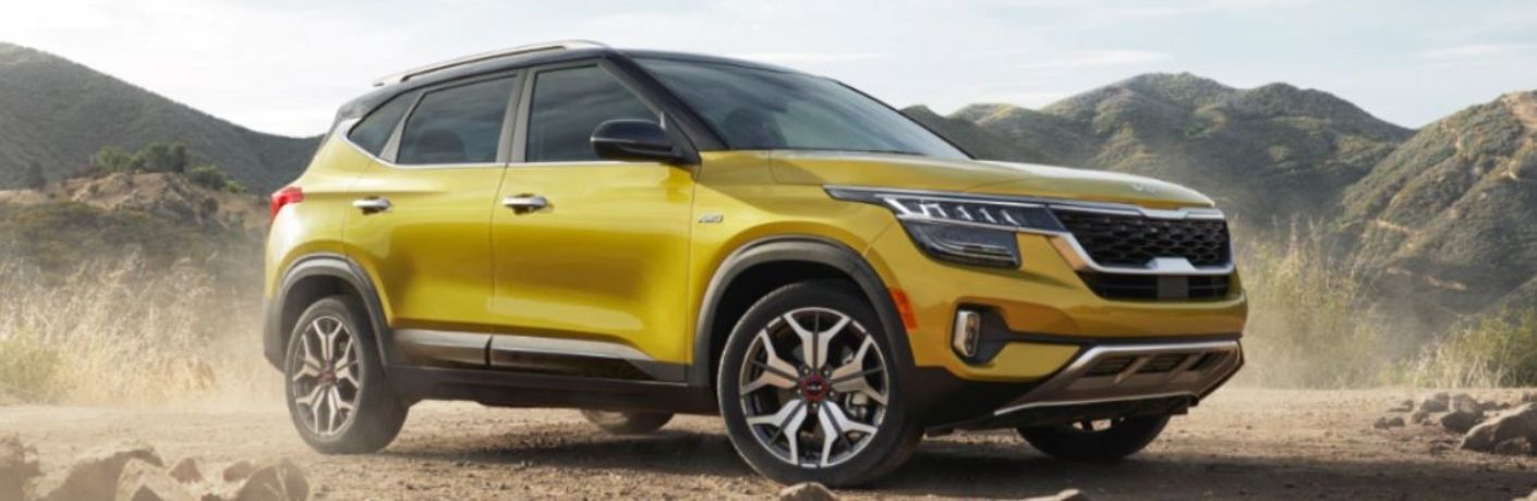 Side quarter view of a yellow 2022 Kia Seltos on rocky terrain