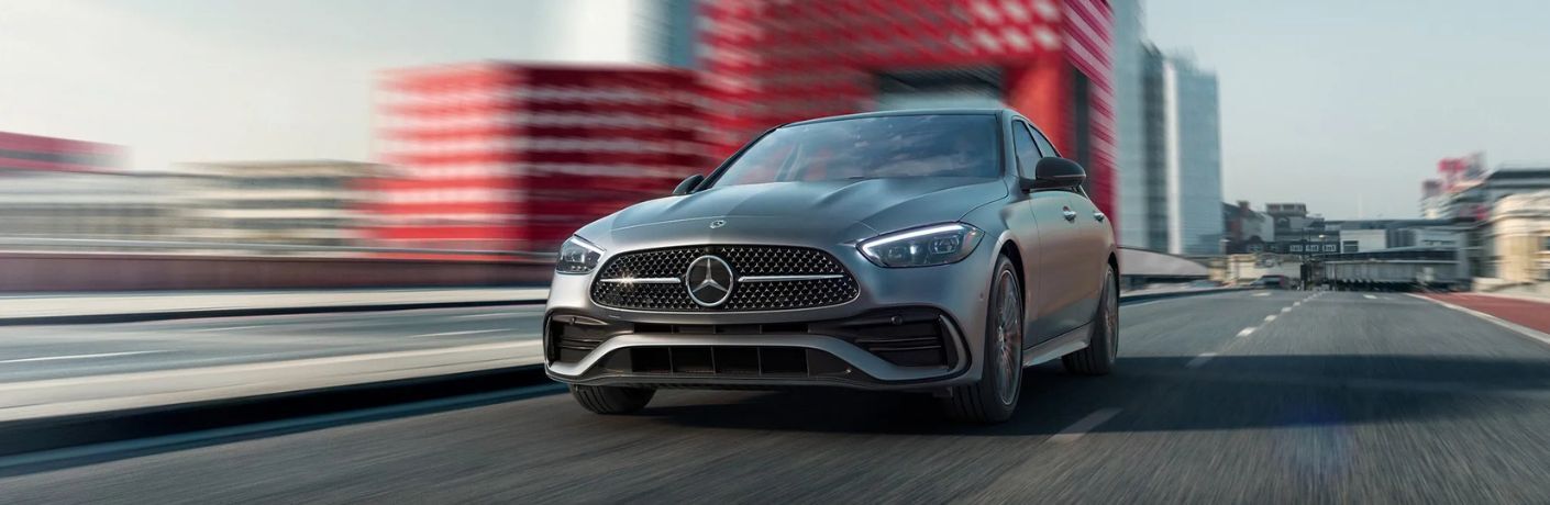 front view image of the 2025 Mercedes-Benz C 300 4MATIC Sedan on a road