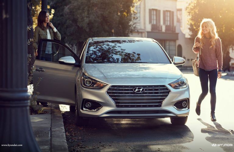 a woman walking next to the 2018 Hyundai Accent