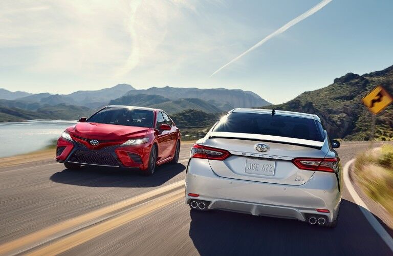 Two 2020 Toyota Camry vehicles passing each other on a road