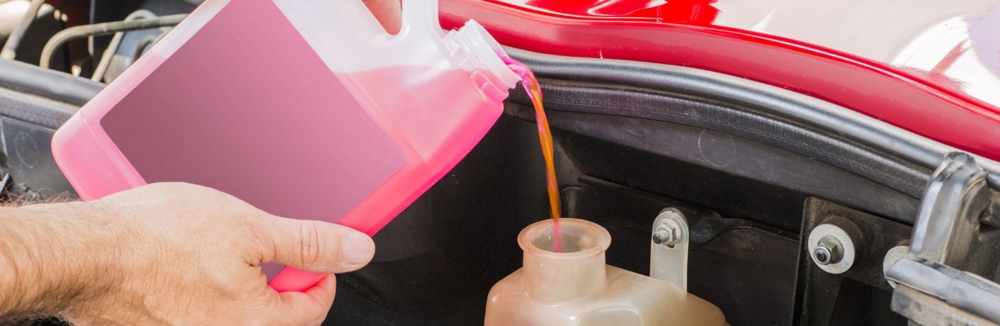 Pink car coolant poured into an engine case