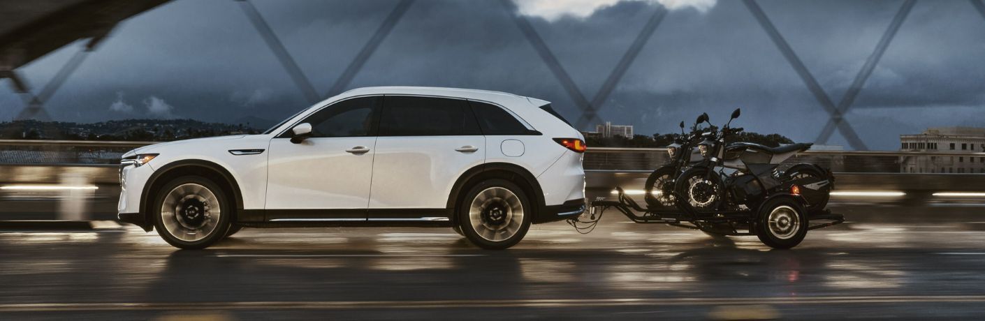 side view of the 2025 Mazda CX-90 towing two bikes
