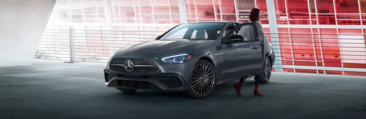 a woman getting out of a Mercedes-Benz C-Class Sedan