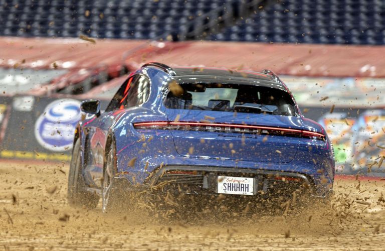 Rear view of the Porsche Taycan Turbo S Cross Turismo on a dirt track