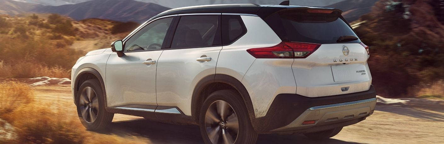 One white color 2022 Nissan Rogue is running on a hilly road.