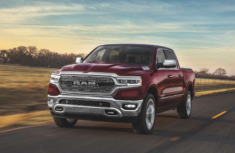 Front driver angle of a maroon 2020 RAM 1500 driving on a road