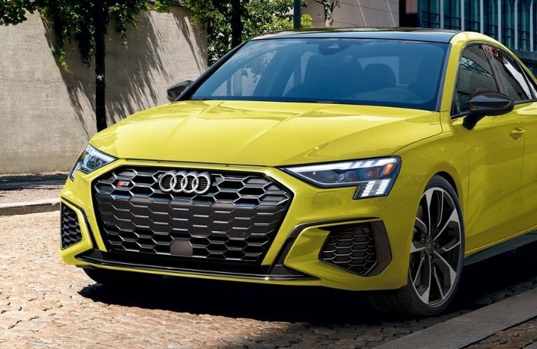 lime yellow Audi car parked on a road near a building