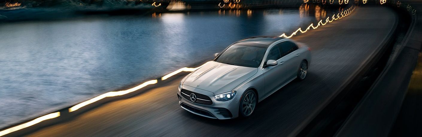 Mercedes-Benz sedan on a road near a lake