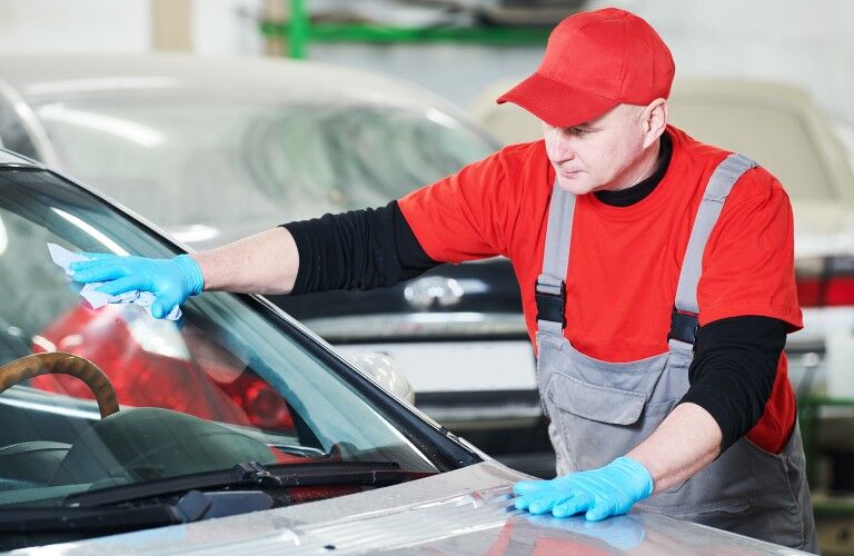Mechanic repairing a crack on a windshield