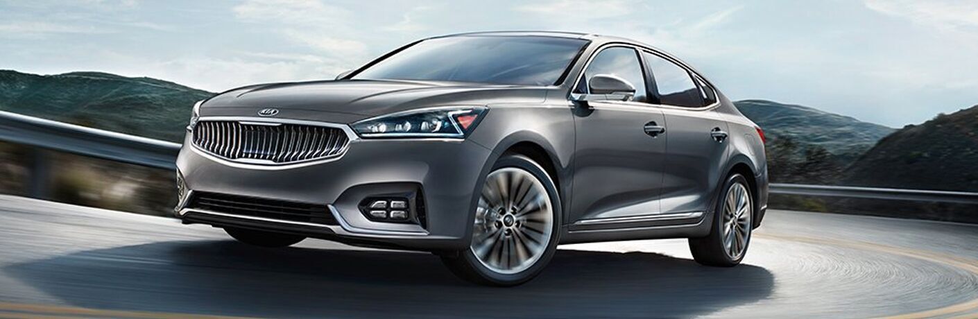 Exterior view of a silver 2019 Kia Cadenza driving down a two-lane highway