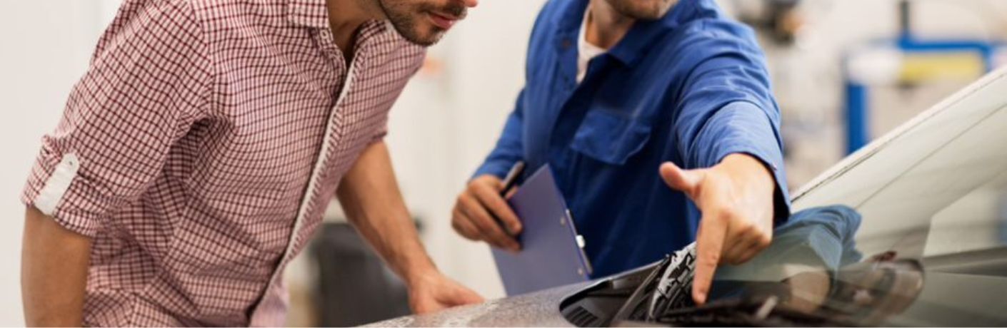 two people looking a car's wipers