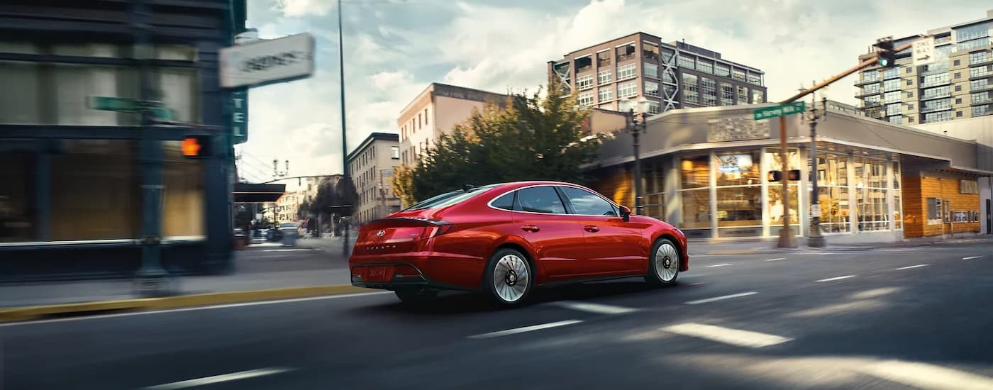 Red 2022 Hyundai Sonata driving on a city street