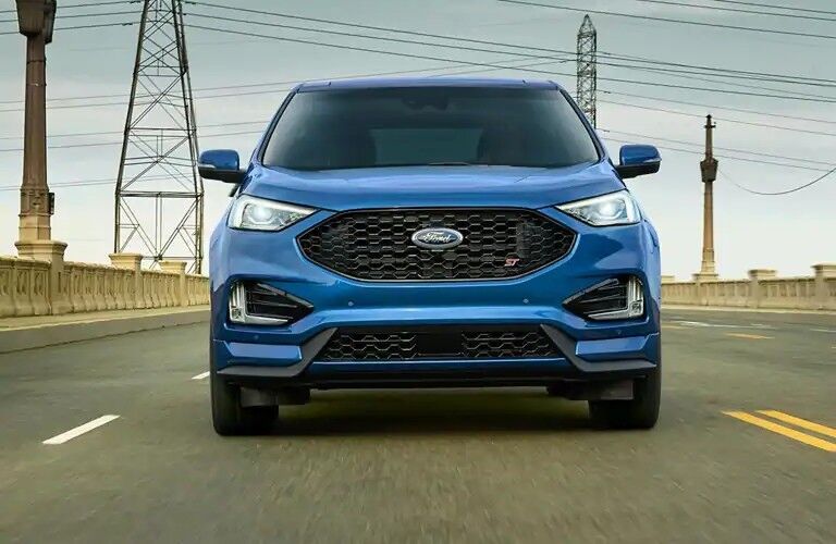 Front view of blue 2020 Ford Edge ST driving over bridge