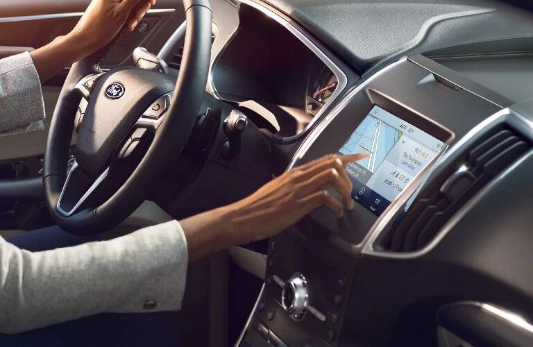 Woman operating touchscreen of 2020 Ford Edge ST