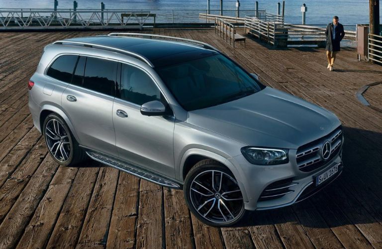 One grey color 2023 Mercedes-Benz GLS is parked near a lake.