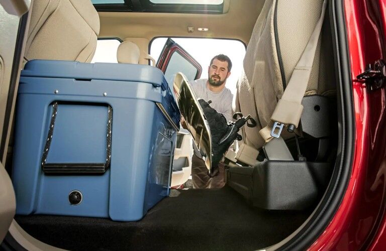 Man loading cargo in second row of 2019 Ford F-150 Lariat seating