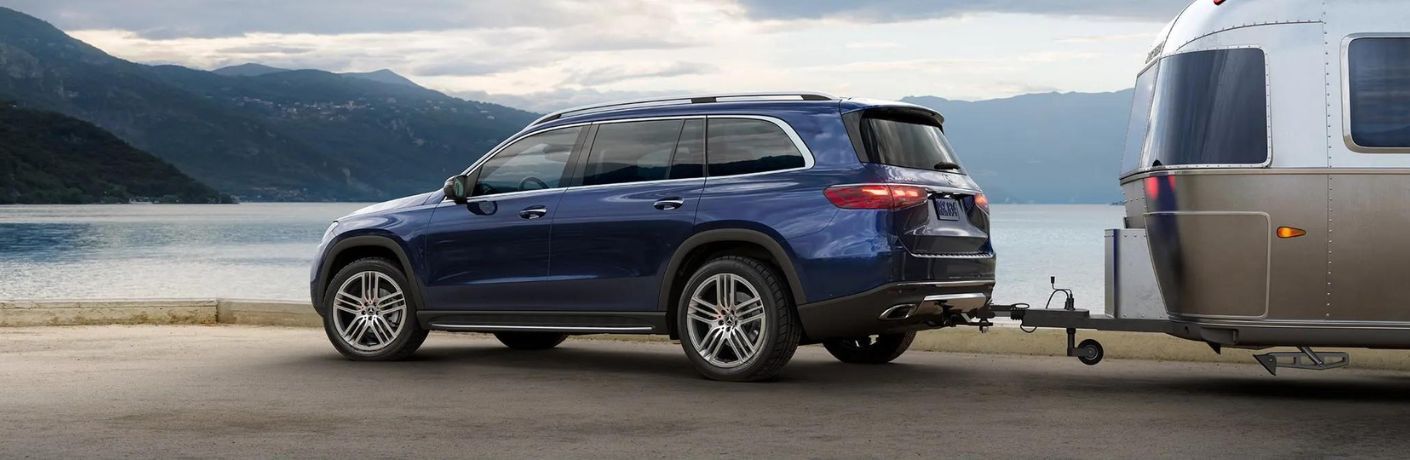 side view image of a 2025 Mercedes-Benz GLS SUV towing a trailer