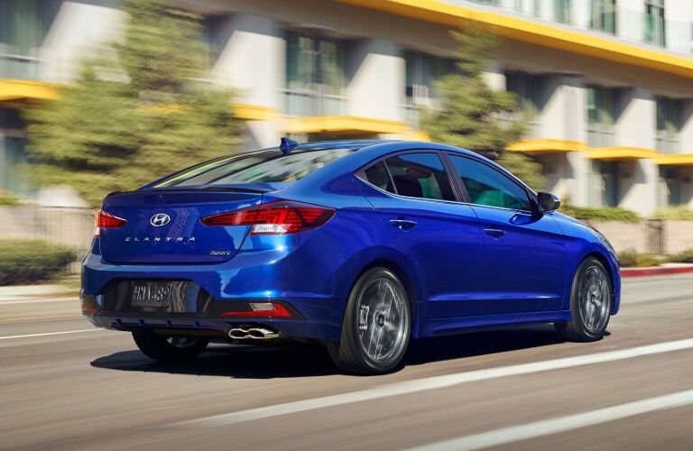 Back side view of blue used Hyundai Elantra moving on the road