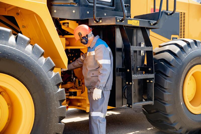A man using the best replacement parts for heavy trucks to repair a specialized vehicle.