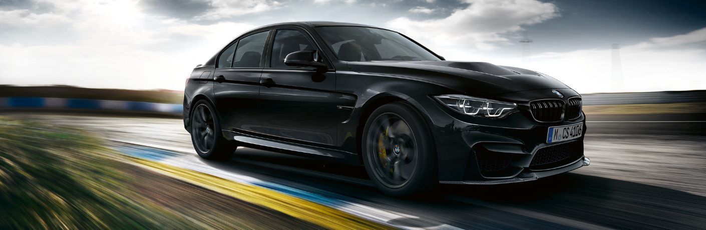 Front three-quarter view of the 2018 BMW M3 CS driving on a racetrack