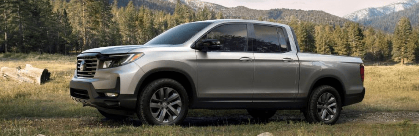 One grey color 2023 Honda Ridgeline is parked on the grass.