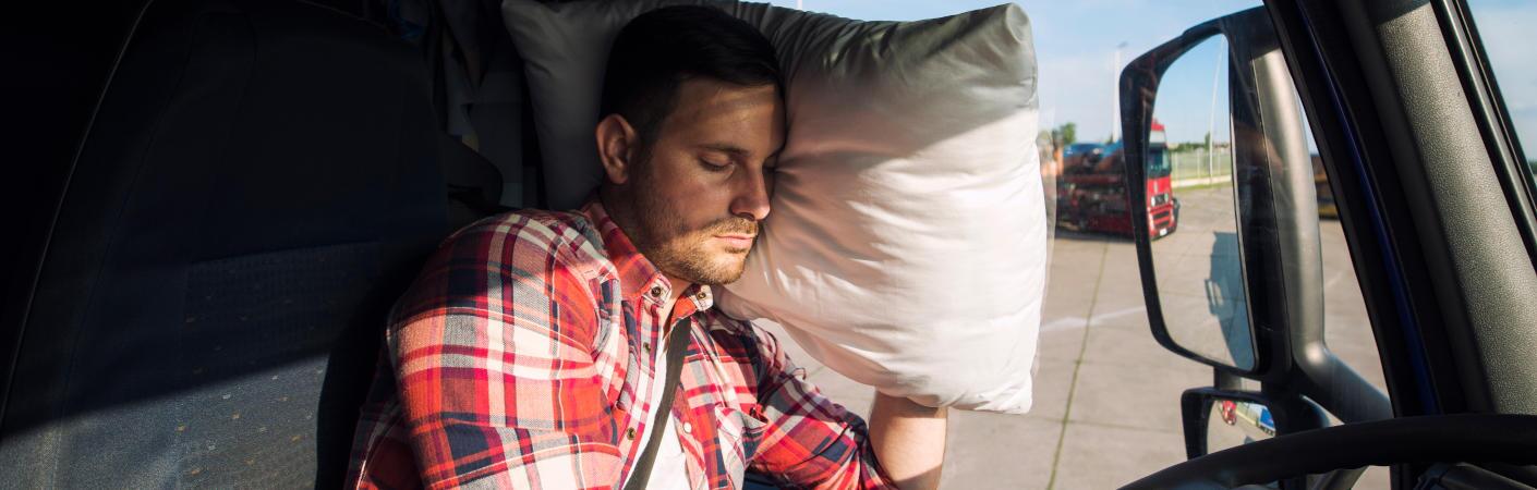 A man sleeping in his semi truck.