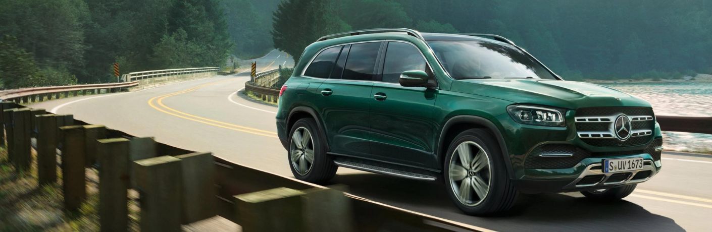 One green color 2023 Mercedes-Benz GLS is running on the road.