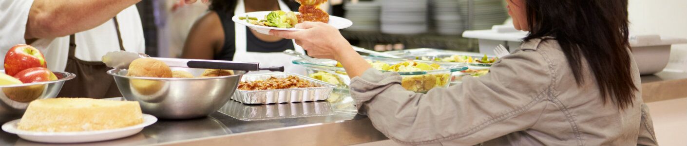 man pushing old car up gradual incline