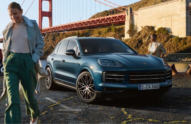 2026 Porsche Cayenne E-Hybrid paked behind a women