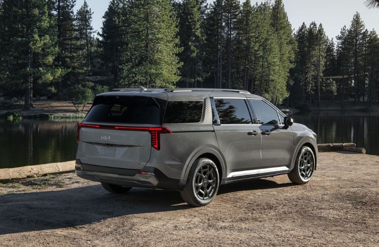 rear view of the 2025 Kia Carnival parked near a lake