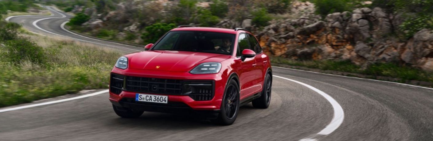 a red color 2025 Porsche Cayenne on the road
