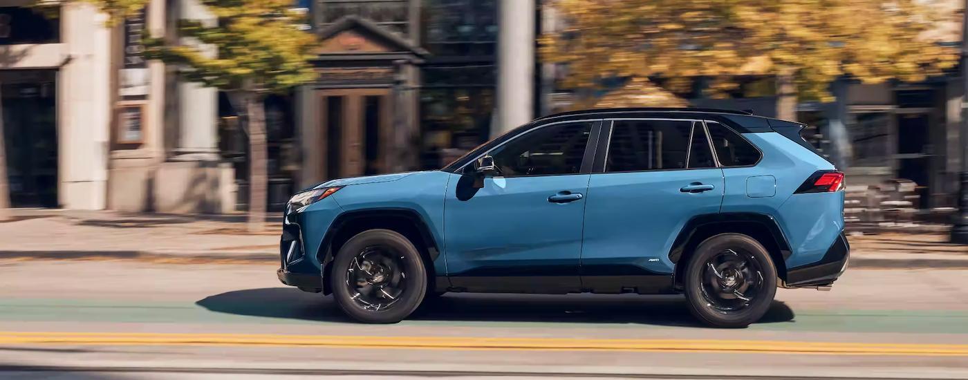 A blue 2023 Toyota RAV4 XSE SUV for sale near Hackensack driving on a city street.