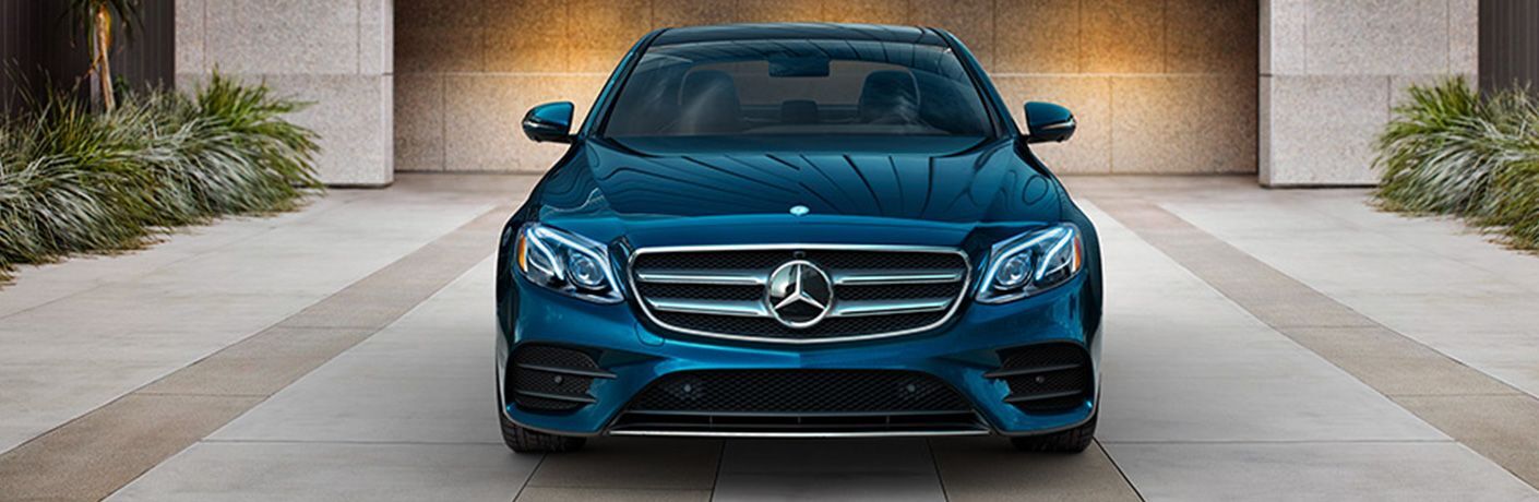 blue Mercedes-Benz E-Class parked outside garage