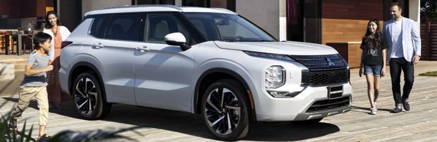 A family of four around the 2023 Mitsubishi Outlander