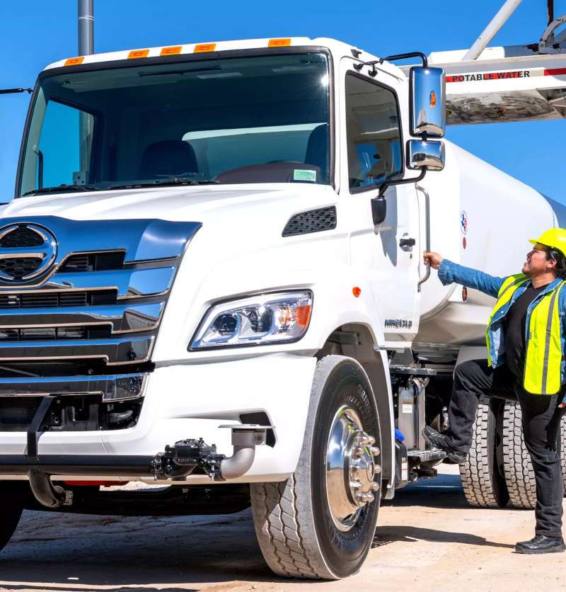 A rear quarter exterior view of a large Hino grapple truck