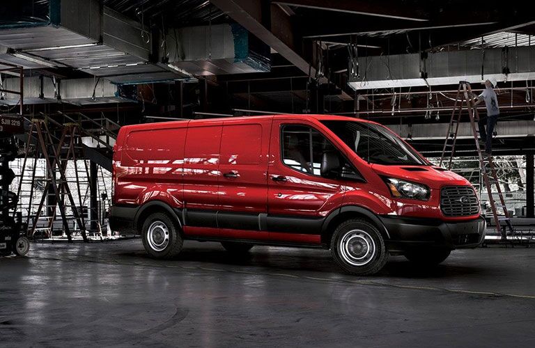 side view of red 2018 ford transit cargo van at job site