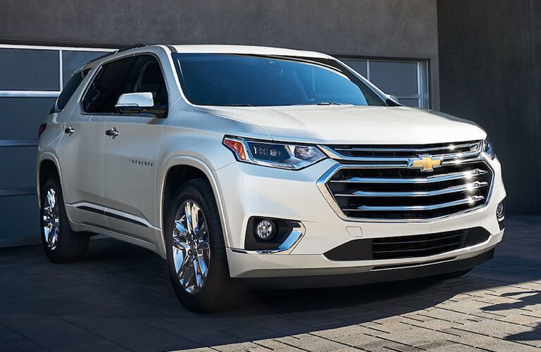 front view of white 2019 chevrolet traverse in front of modern garage