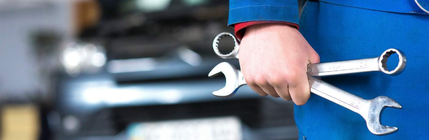 Mechanic Holding Wrenches in Hand