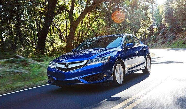 full view of the Acura ILX driving on a forest road