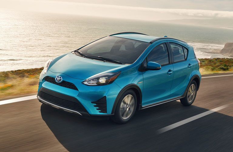 Toyota Prius c driving by some water