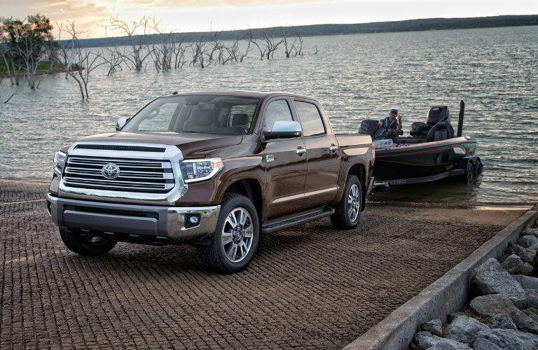 A photo of a 2018 Toyota Tundra pulling a small fishing boat out of a lake