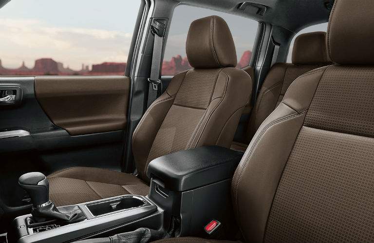 A view from the driver's side of the 2018 Toyota Tacoma showing a special interior material and the center console.