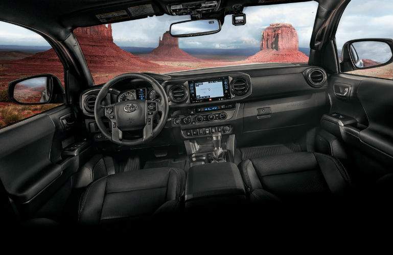 A photo of the dashboard, steering wheel and center gauge cluster of the 2018 Tacoma