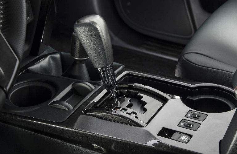A close up photo of the gear shifter and traction control systems