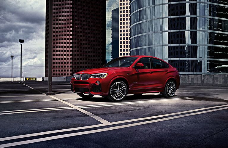 Red 2016 BMW X4 on a city road